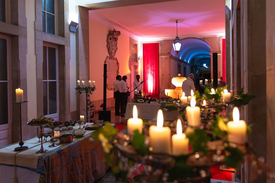 Sala de evento decorada com velas, flores e luz vermelha